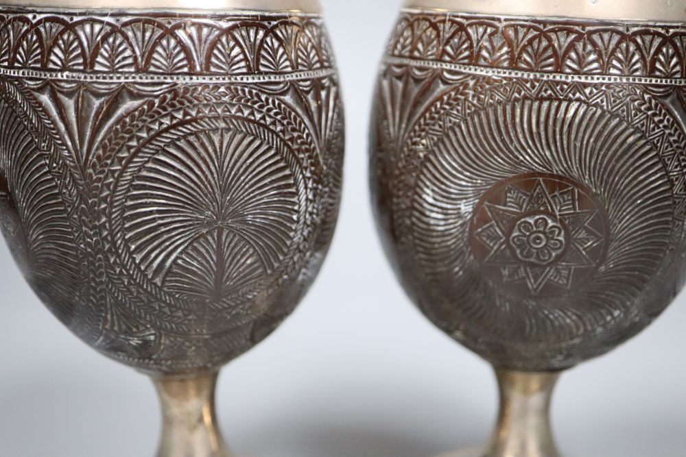 A pair of 19th century white metal mounted coconut cups, indistinct marks, 16.6cm.